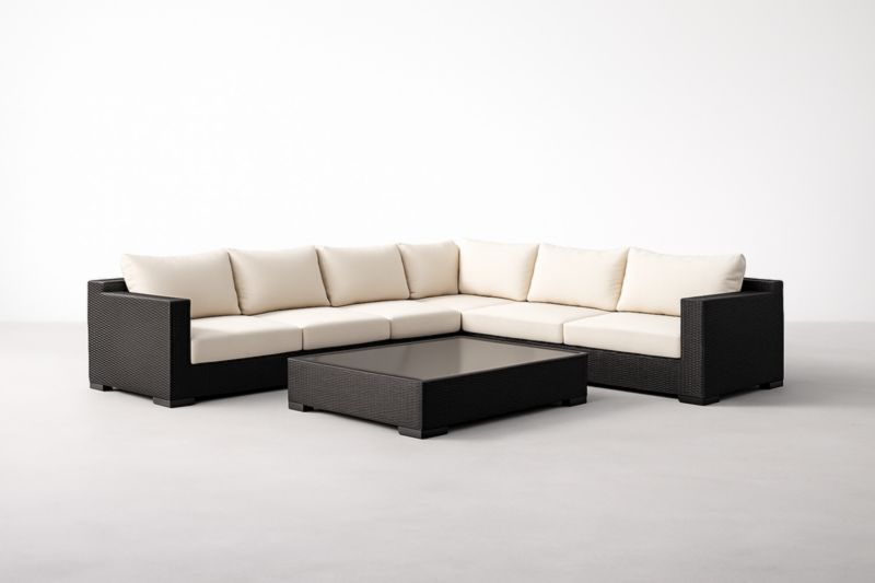 Canapé d'extérieur en résine tressée avec coussins beiges et table basse