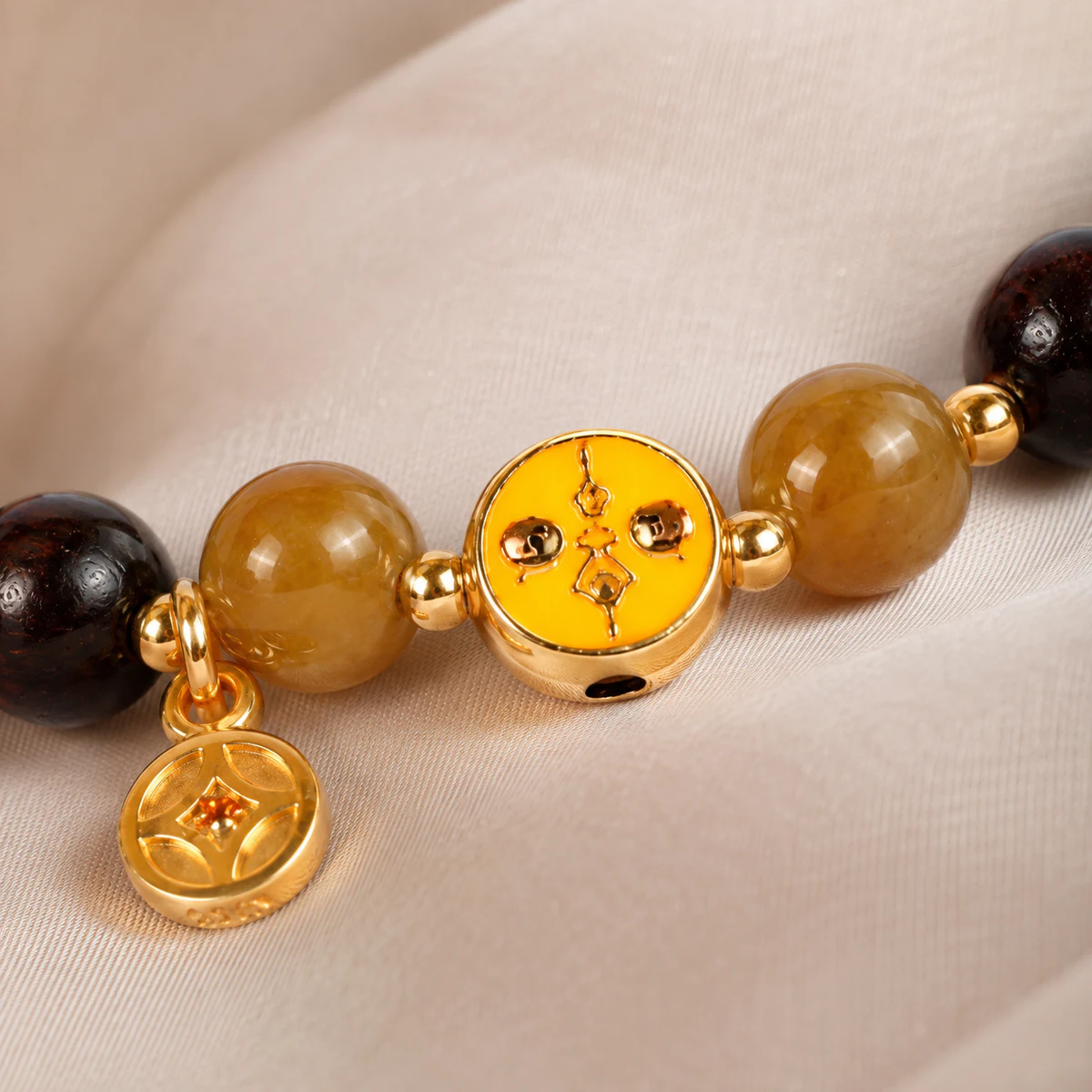 Gold medallion and honey bead bracelet detail