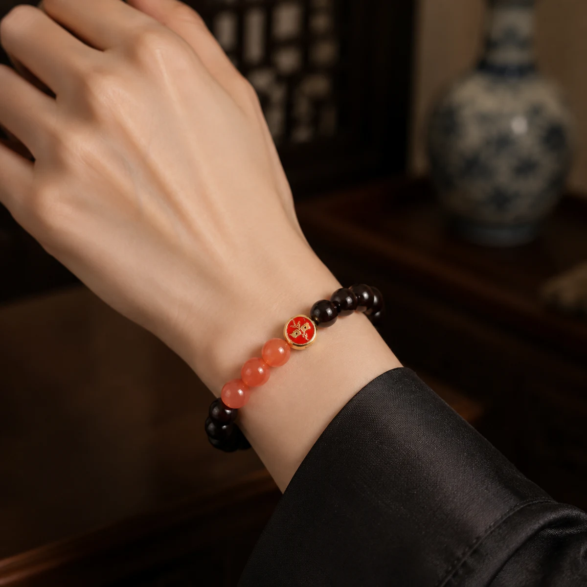 Dark wood and coral bead bracelet worn on wrist