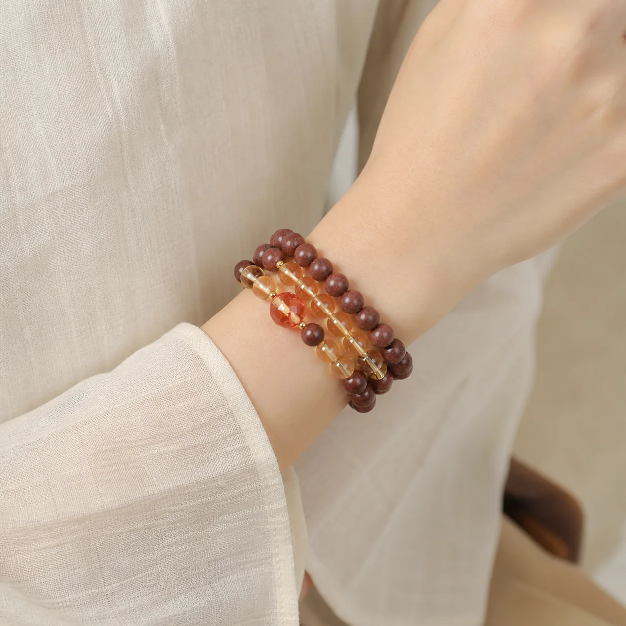 Amber-tone incense bead bracelet worn with linen