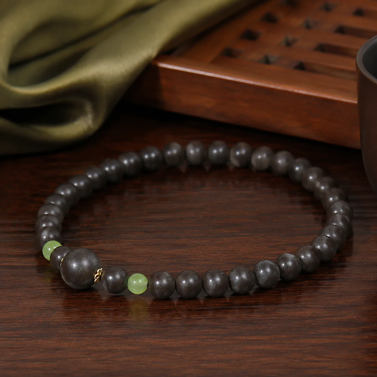 Dark incense bead bracelet with green accent in a new Chinese setting