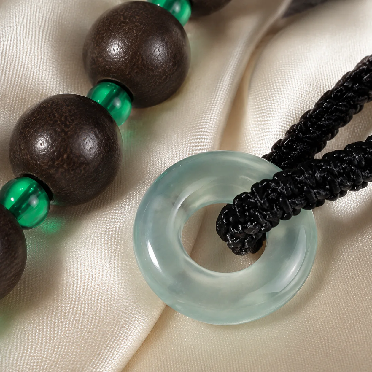 Pale green pendant detail on dark wood bead necklace