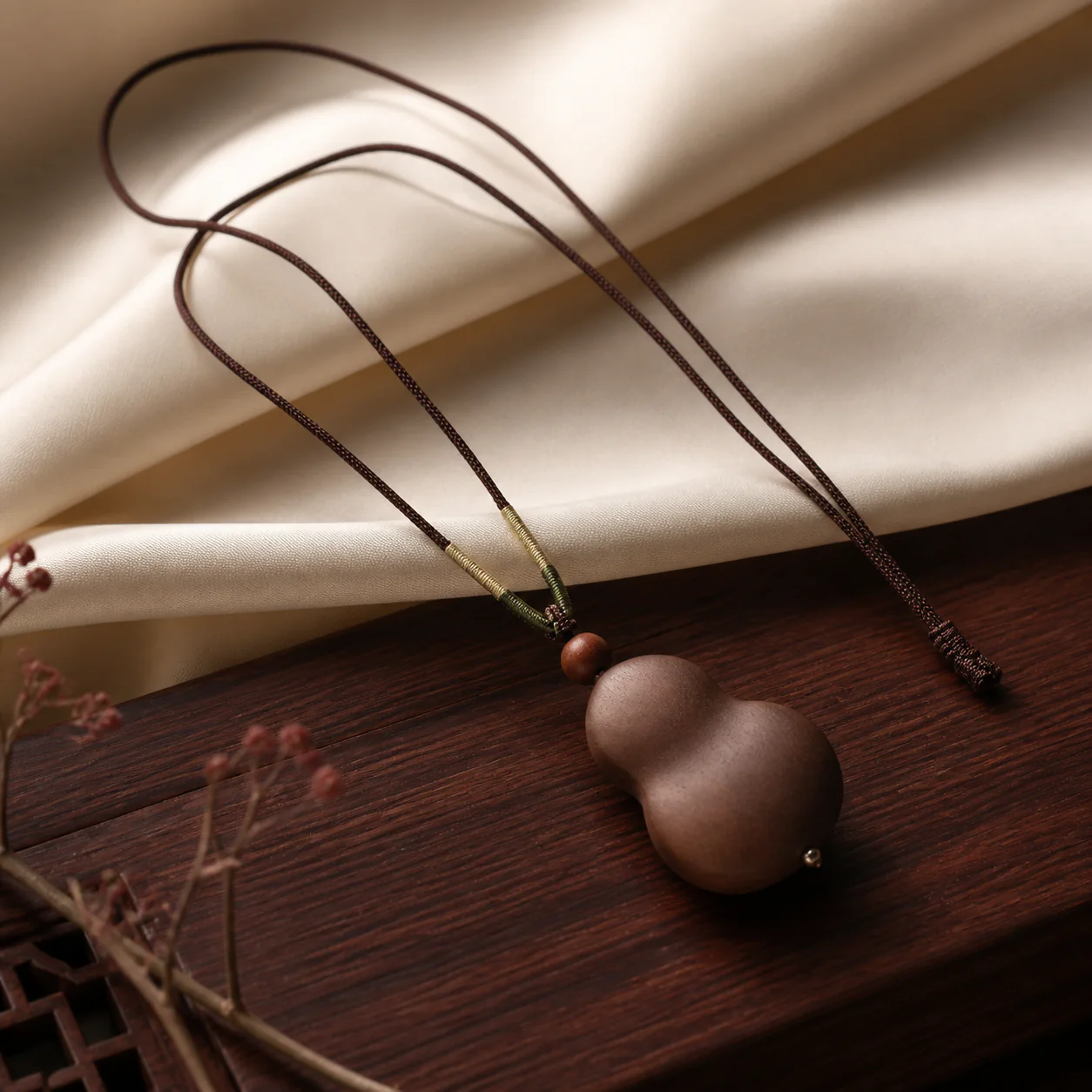 Dark wood gourd pendant necklace in a refined setting