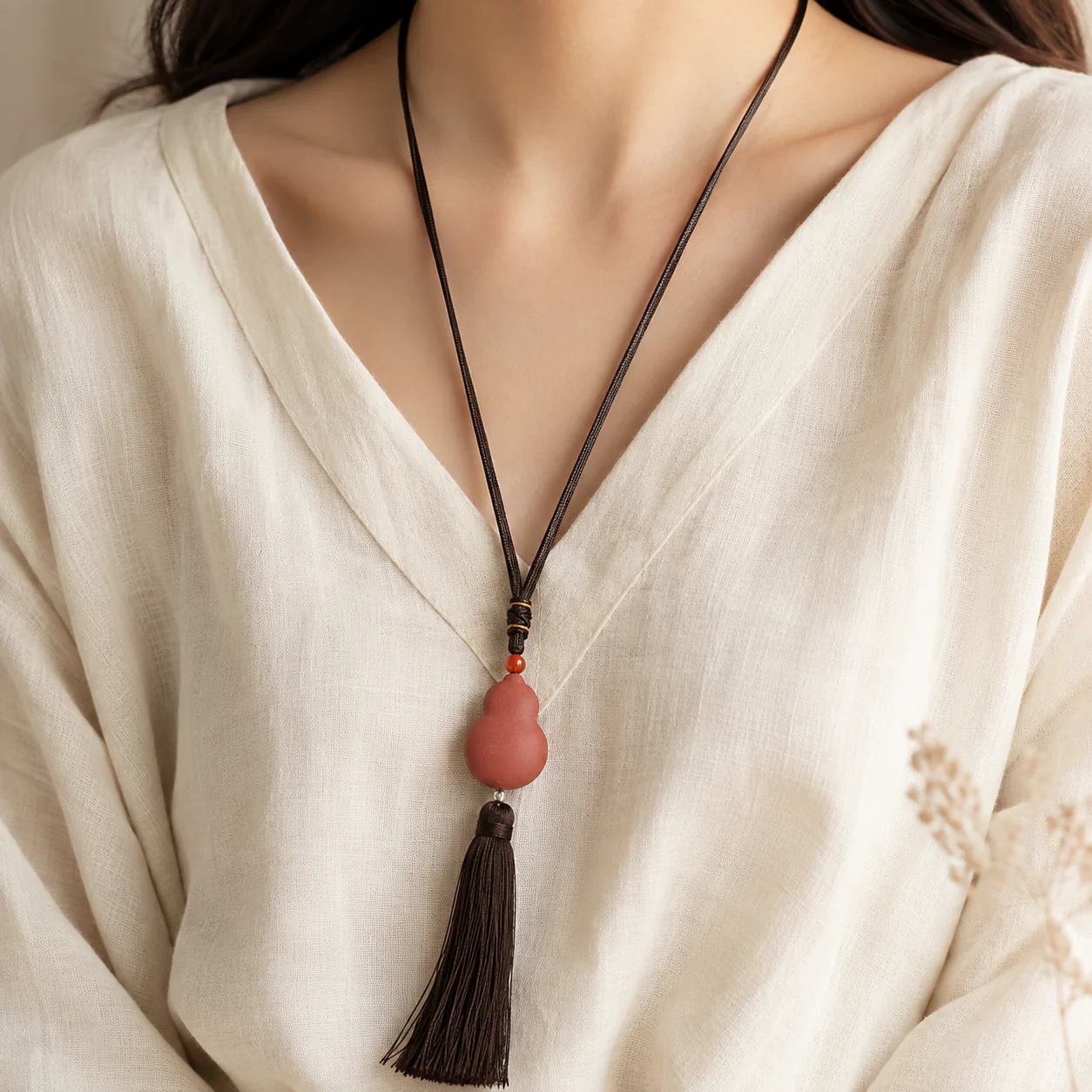 Terracotta gourd tassel pendant worn with linen