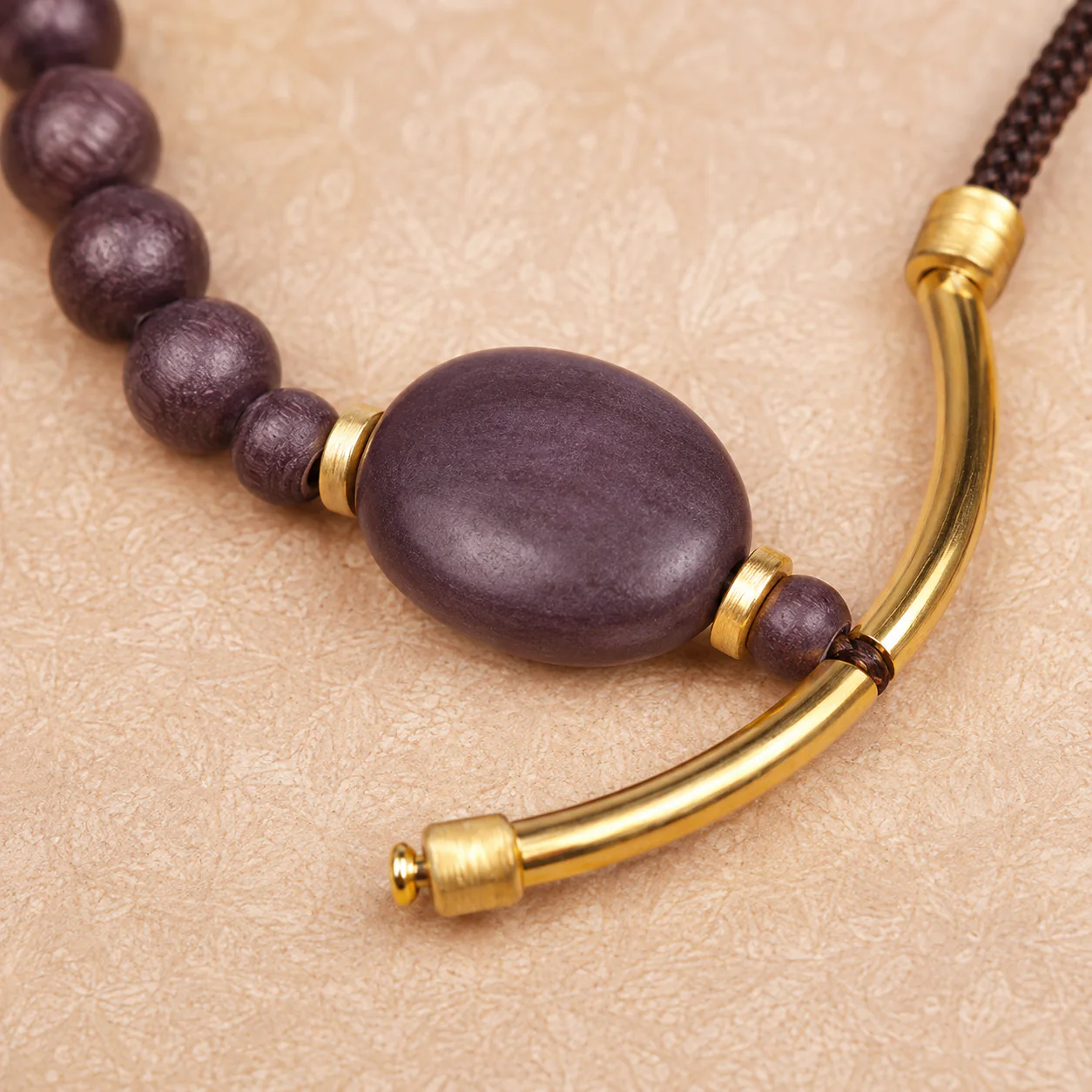 Plum wood bead and gold bangle bracelet material detail
