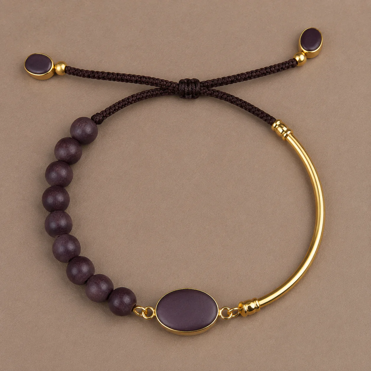 Plum wood bead and gold bangle bracelet cord detail