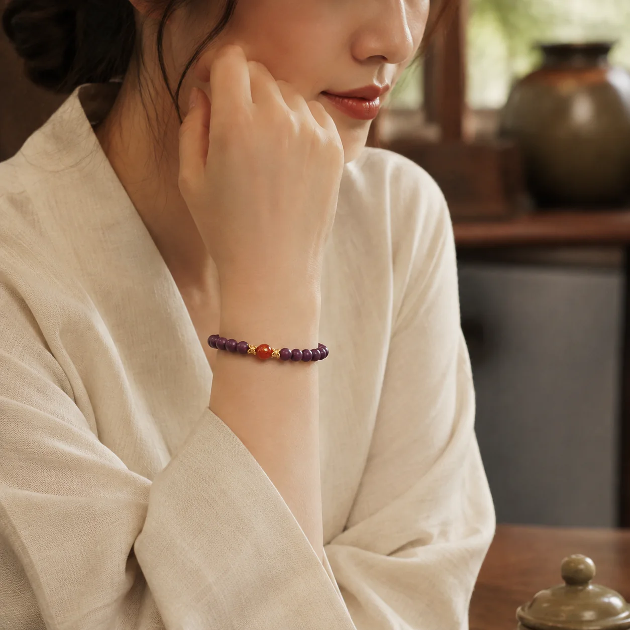Plum wood bead bracelet with red agate accent worn with linen