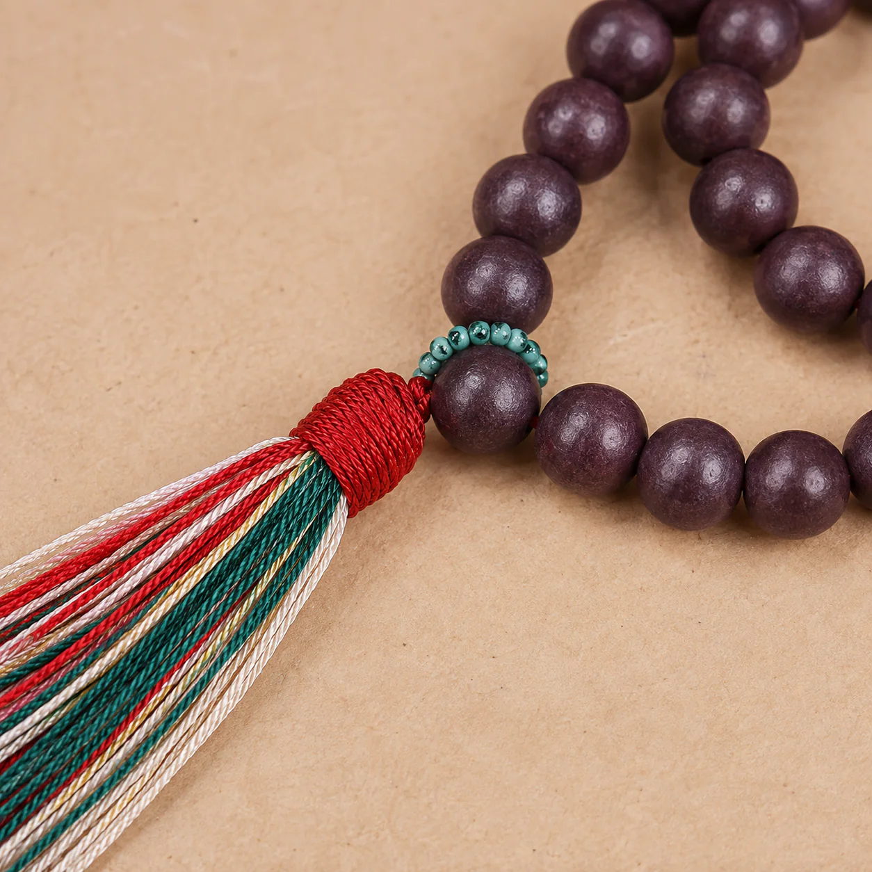 Plum wood bead strand and tassel material detail