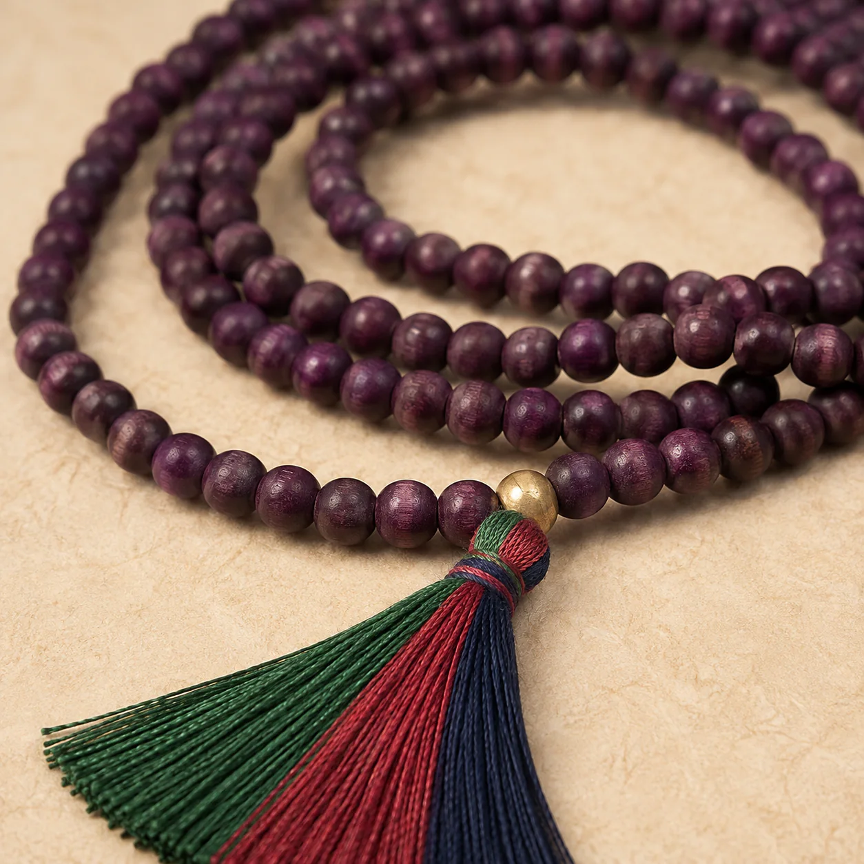 Plum wood bead mala tassel and material detail