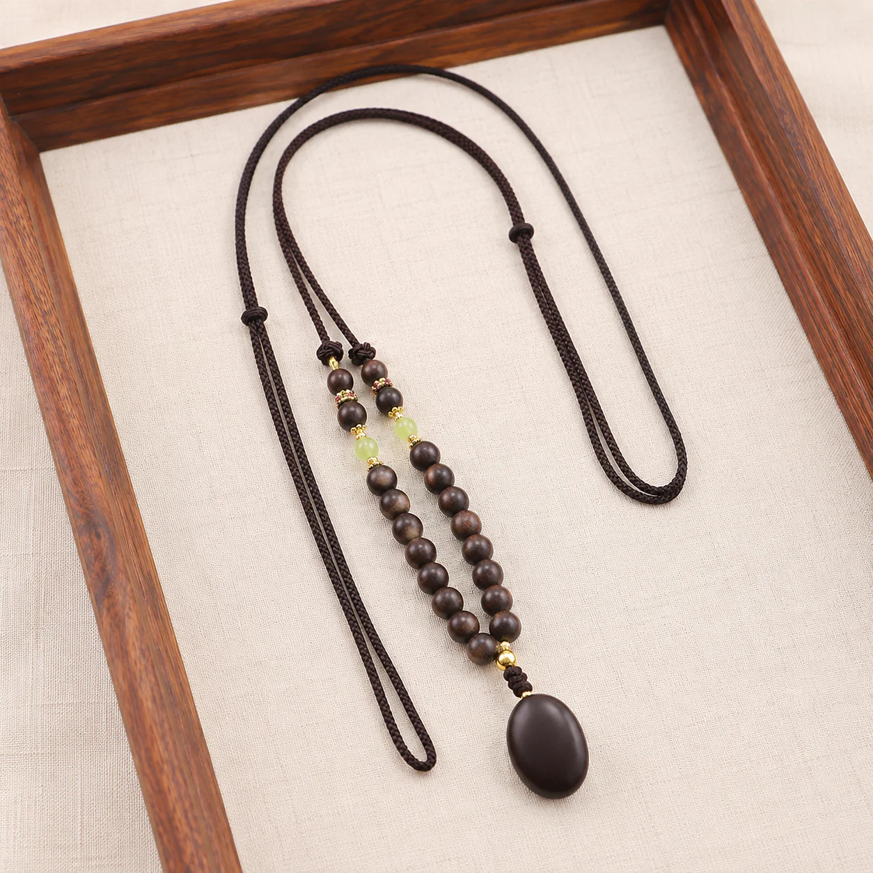 Dark wood bead pendant necklace in a refined setting