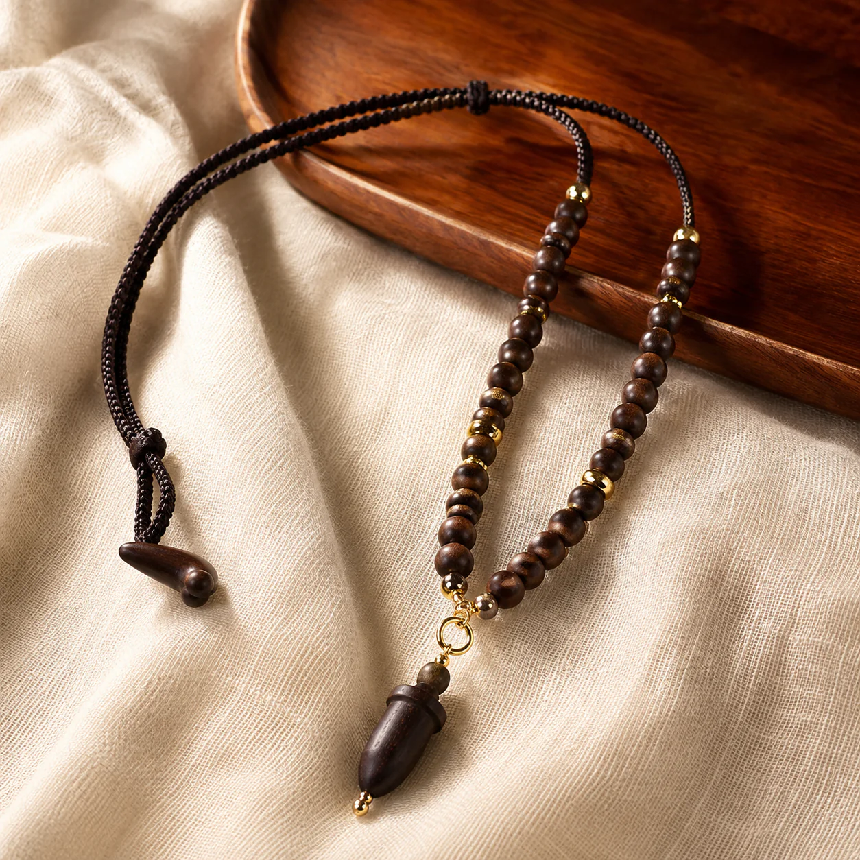 Dark wood bead pendant necklace in a refined setting