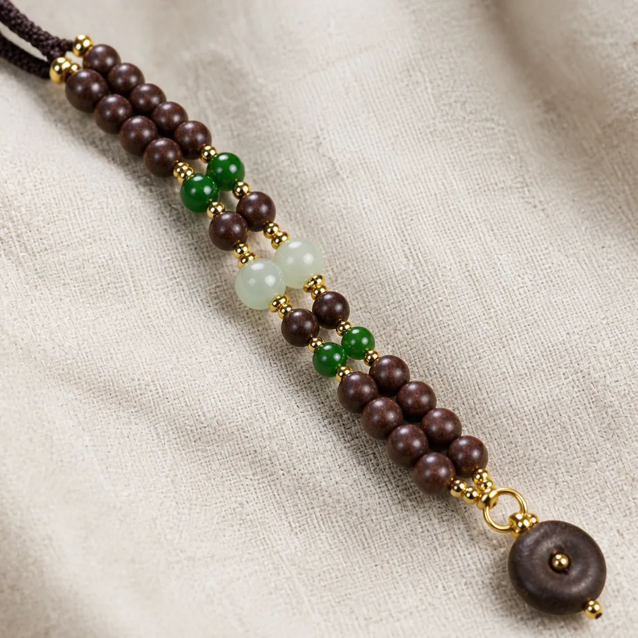 Dark wood bead necklace with green accents material detail