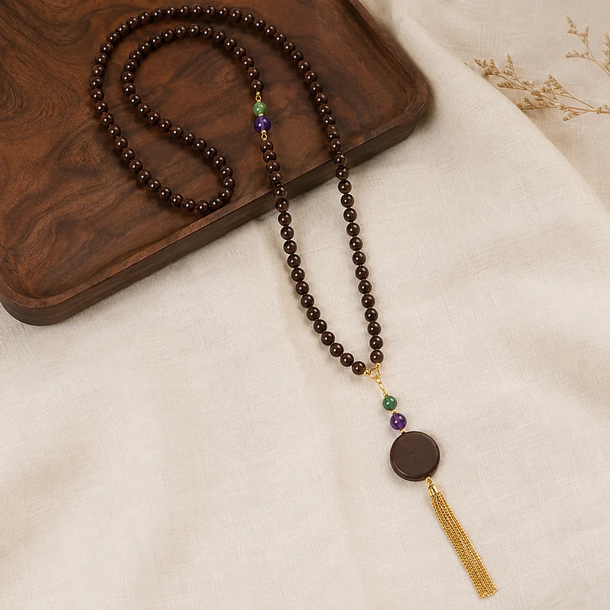 Long dark wood bead necklace in a refined setting