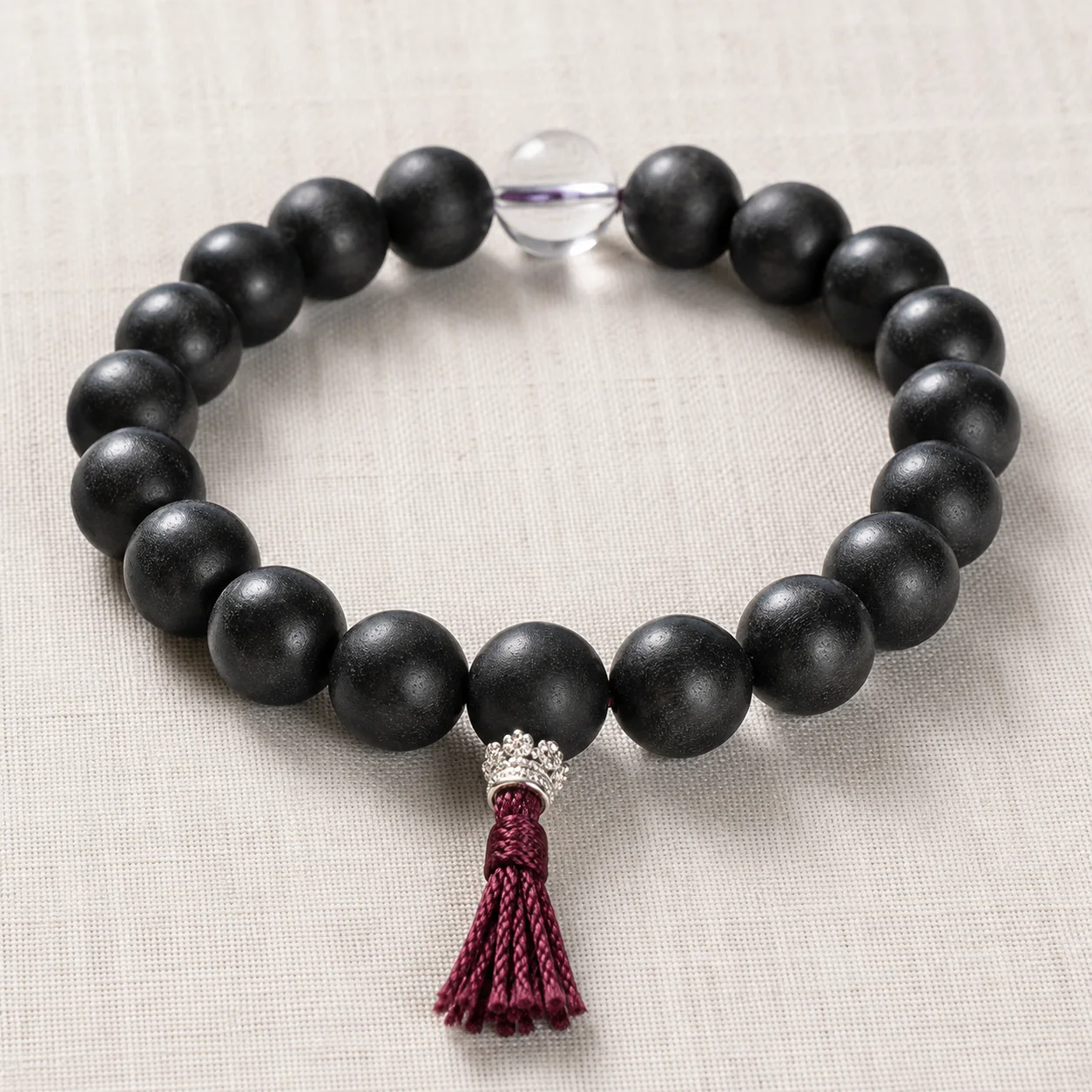 Dark wood bead bracelet with tassel material detail