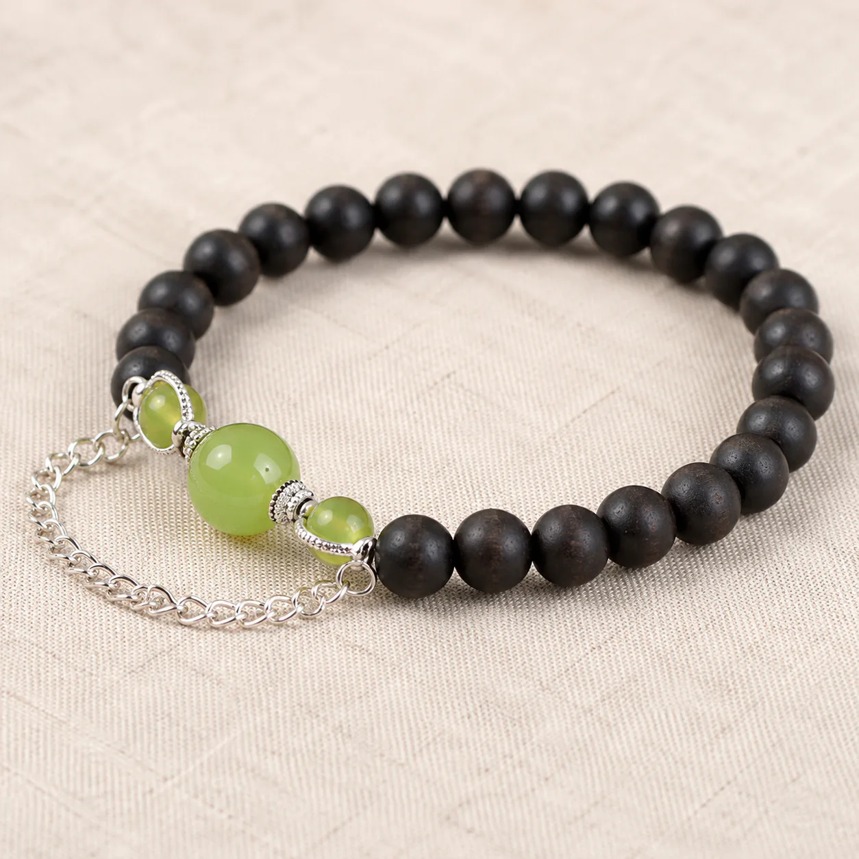 Dark wood bead bracelet with green stone material detail