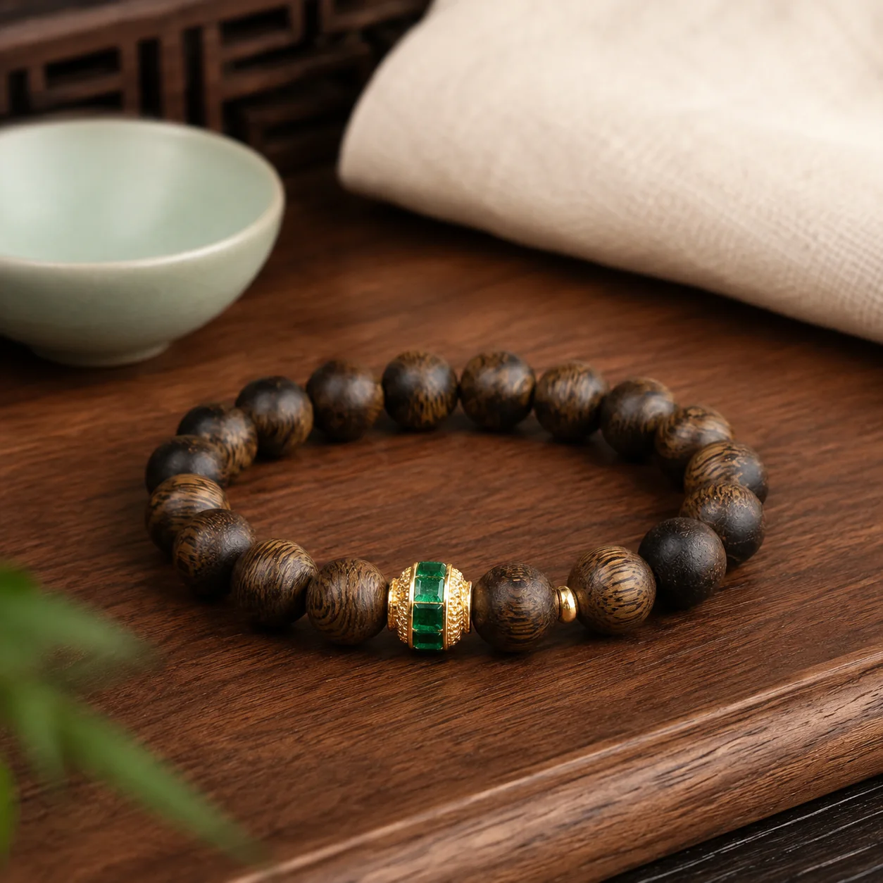 Agarwood bracelet with green gemstone accent in a refined setting