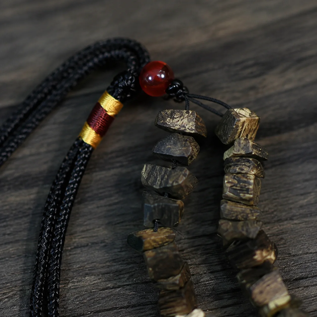 Irregular agarwood prayer beads cord and red bead detail