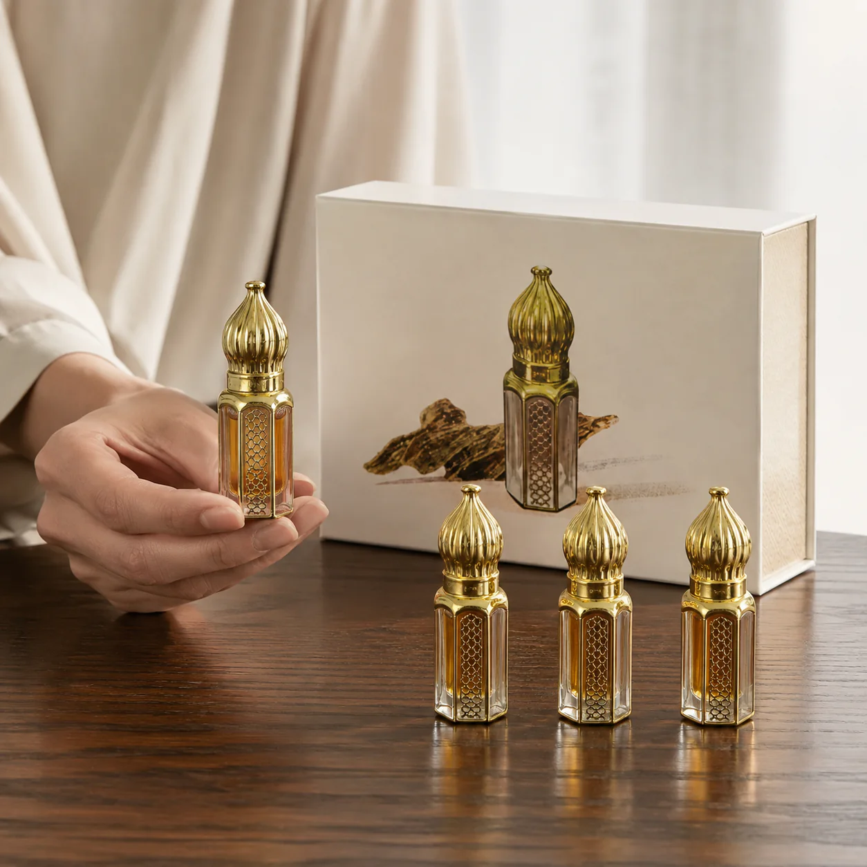Agarwood fragrance oil bottle held by hand with the four-piece set