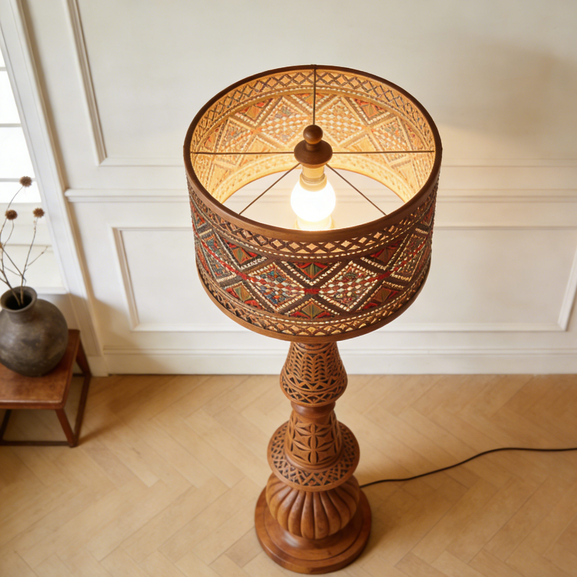 Cylindryczna lampa stojąca z drewnianą rzeźbą
