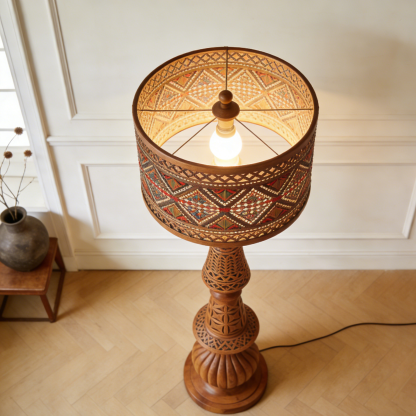 Cylindryczna lampa stojąca z drewnianą rzeźbą
