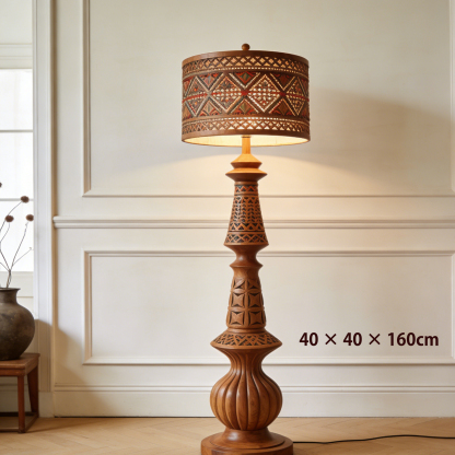 Cylindryczna lampa stojąca z drewnianą rzeźbą