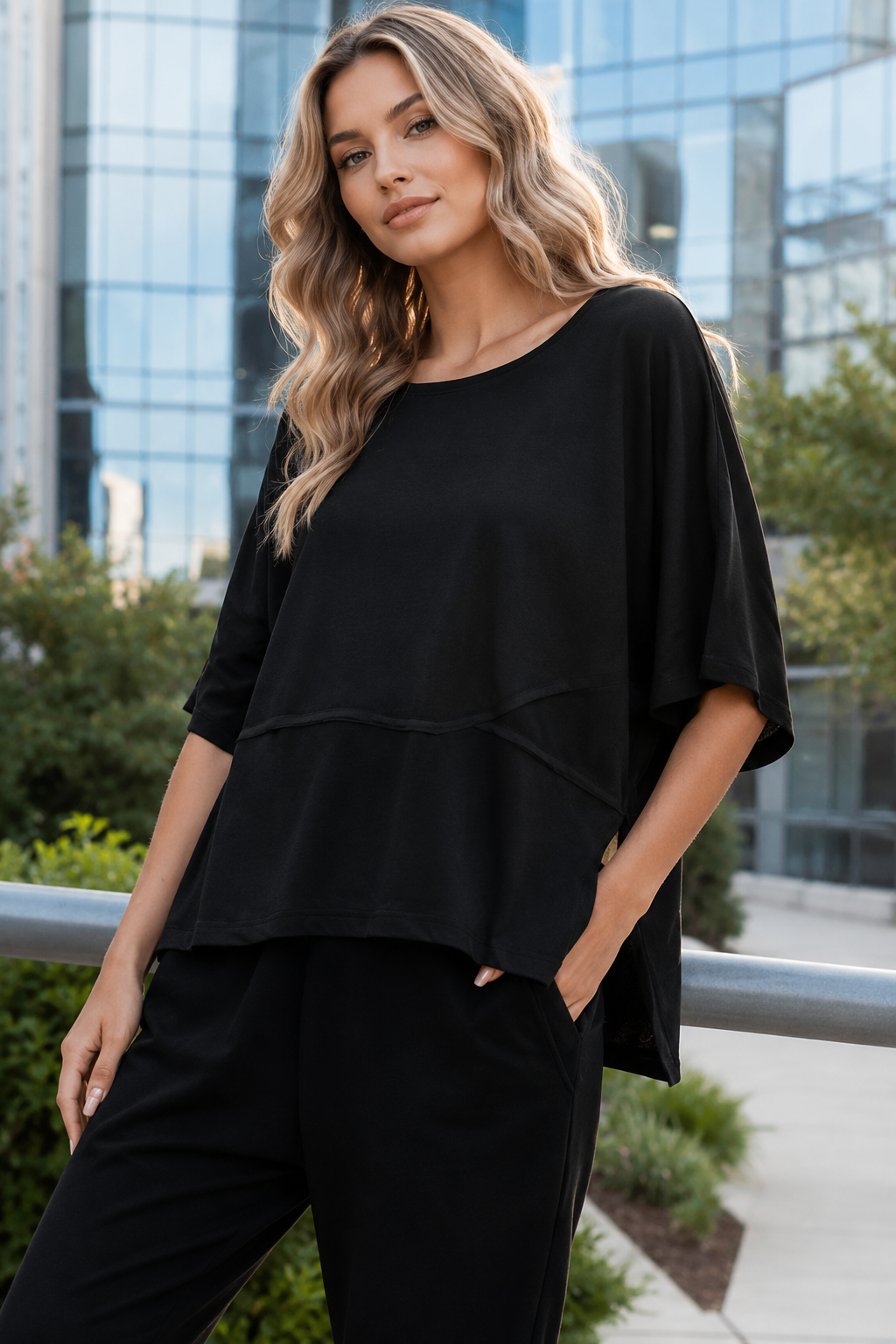 Women's top featuring a clean round neck, soft cotton-blend fabric, and slightly flared three-quarter sleeves.
