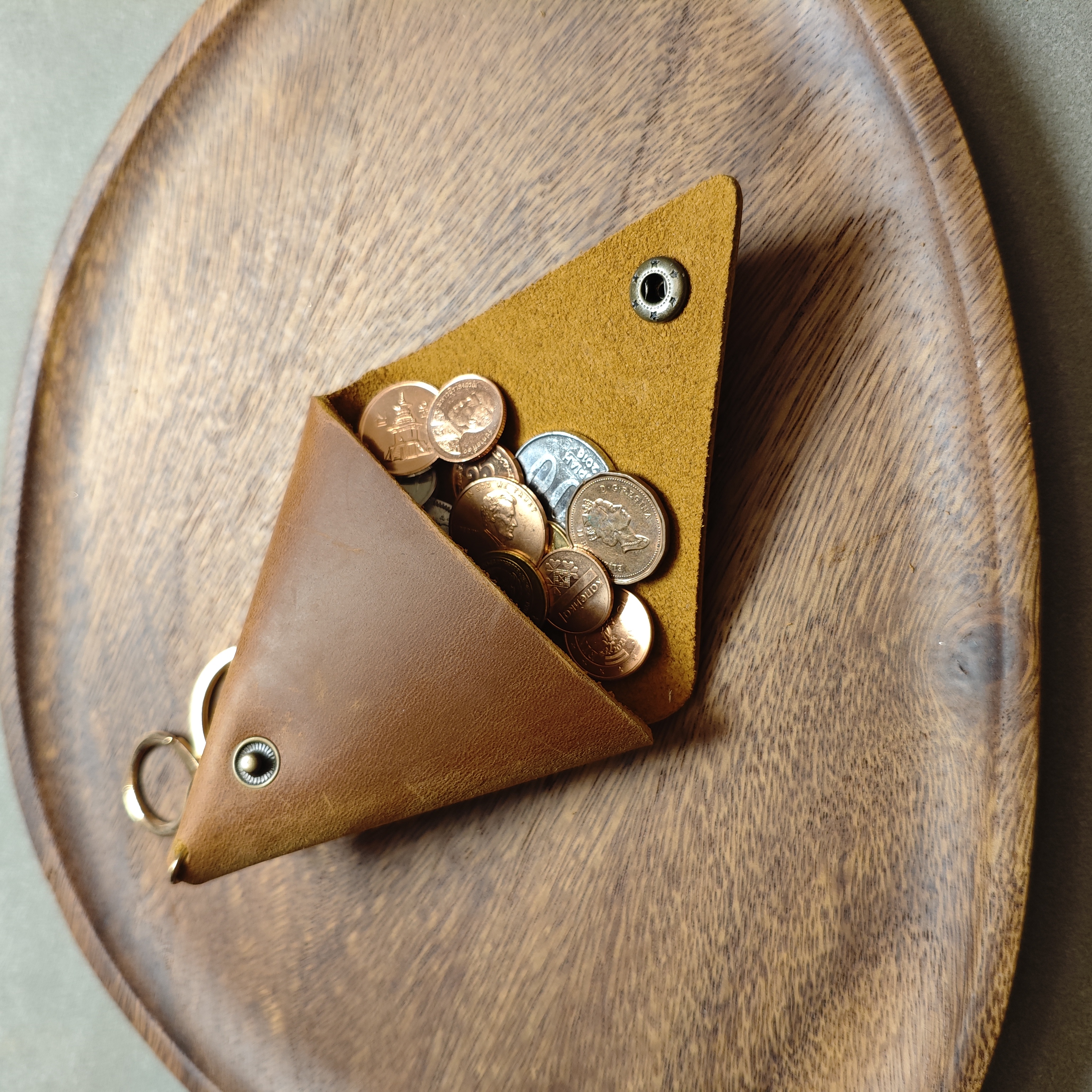 Hand-folded triangle crazy horse leather coin pouch filled with gold and silver coins
