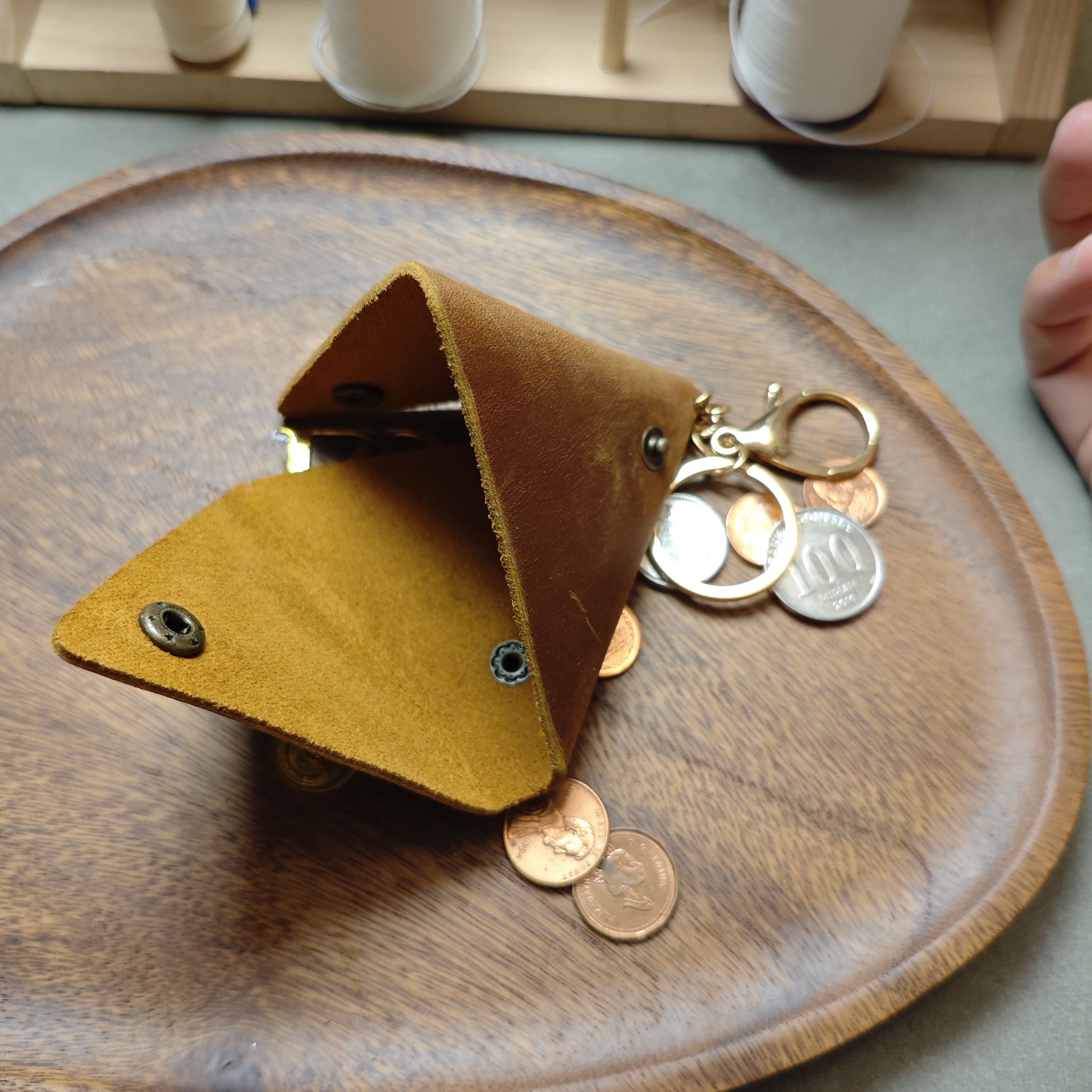 Open triangle leather pouch showing inside suede surface and brass snap closure