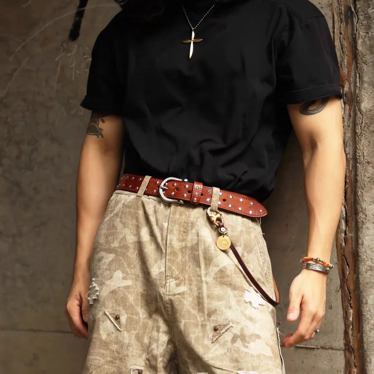 Western studded belt in brown worn with a black tee and camo cargo shorts