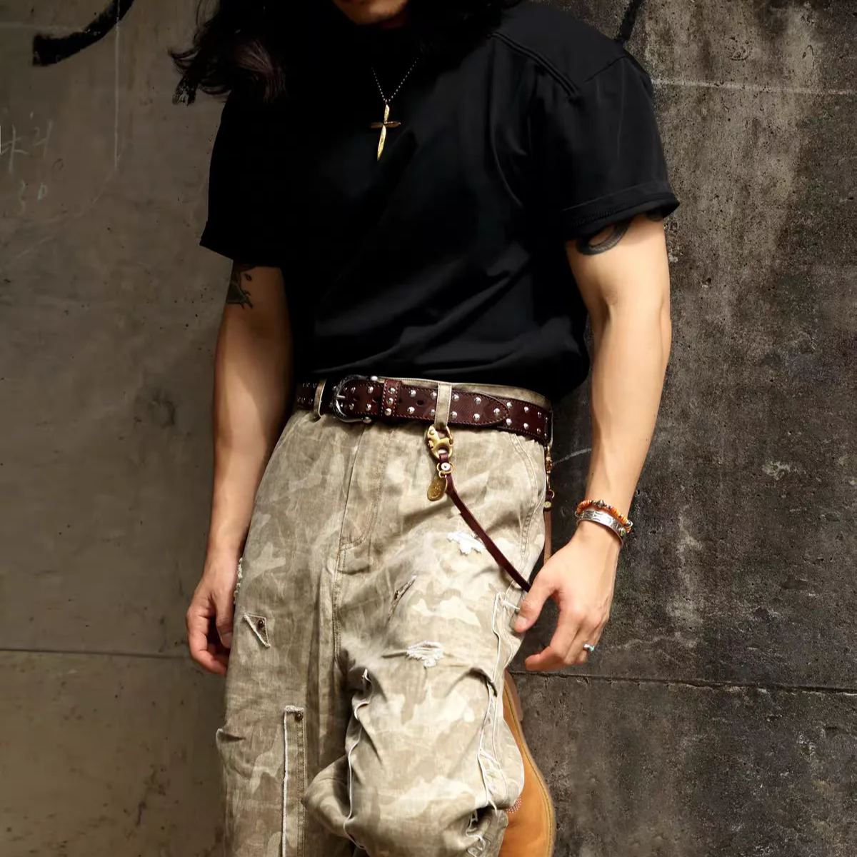 Western studded belt in dark brown worn as the focal point of a simple outfit