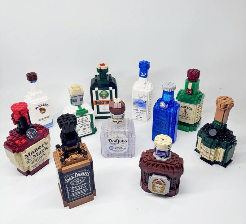 May include: A collection of liquor bottles, each constructed from colorful building blocks. Brands include Maker's Mark, Jack Daniel's, and Grey Goose. The bottles vary in size and color, with detailed labels and caps.