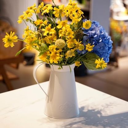 Soft white AnnieGarden metal pitcher vase with yellow and blue flowers