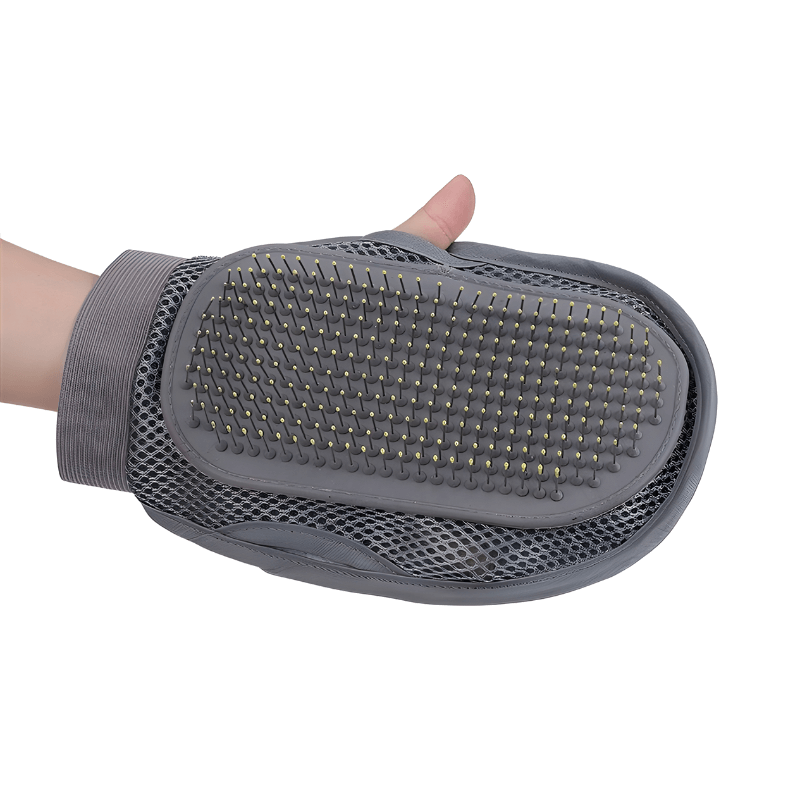 Gray grooming glove with textured surface held by a hand on a white background