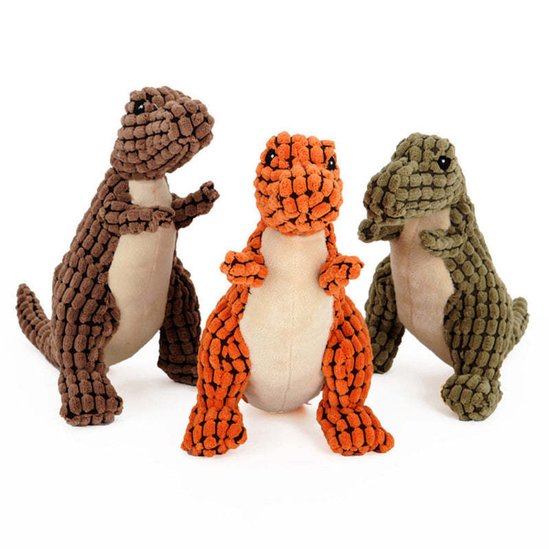 Three dinosaur-shaped dog toys in brown, orange, and green on a white background