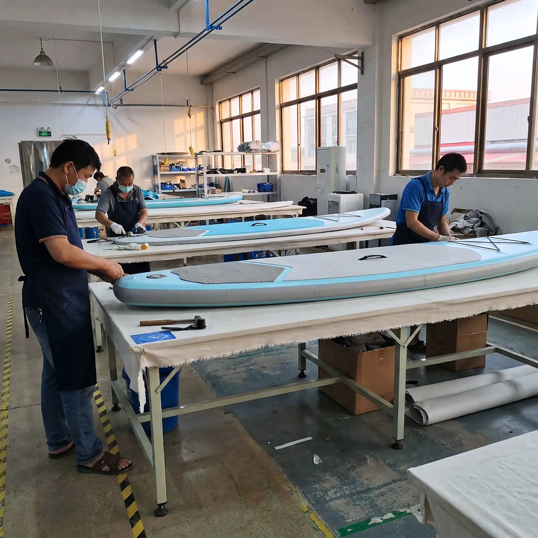 {"default":"Workers building custom OEM inflatable paddle board prototype"}
