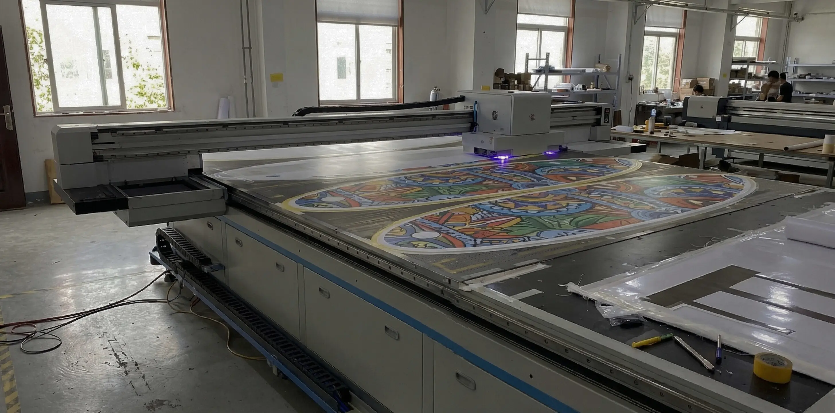 {"default":"Industrial UV printer applying custom graphics to SUP board"}
