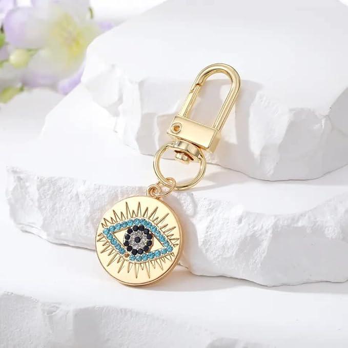Silver Gold Evil Eye Keychain for Women Protection Good Luck Charms Key Chain for Car Keys Holder Bag Purse featuring a clean chic eye design and gold and multi color ,perfect for daily /party/casual/office bagcharm/chain charm decoration . Styled against a white stone background.