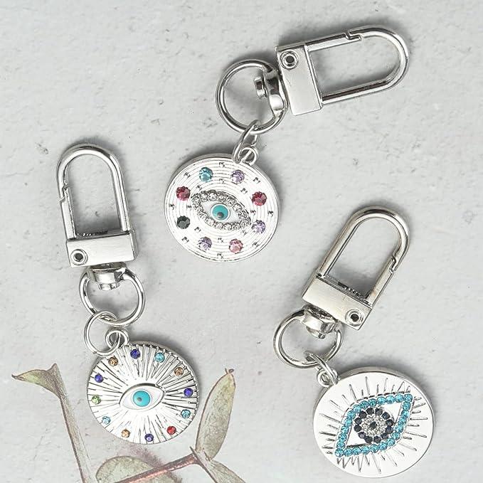 three Silver Gold Evil Eye Keychain for Women Protection Good Luck Charms Key Chain for Car Keys Holder Bag Purse featuring a clean chic eye design and silver and multi color ,perfect for daily /party/casual/office bagcharm/chain charm decoration . Styled against a white  background.