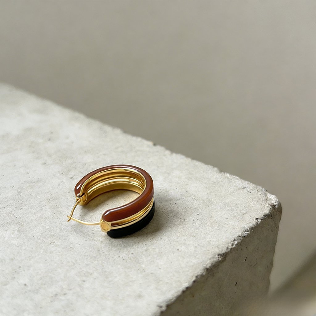 Pair of vintage metal hoop earrings on white background