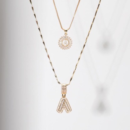 Warstwowa biżuteria – naszyjnik z inicjałem łączony z innymi łańcuszkami