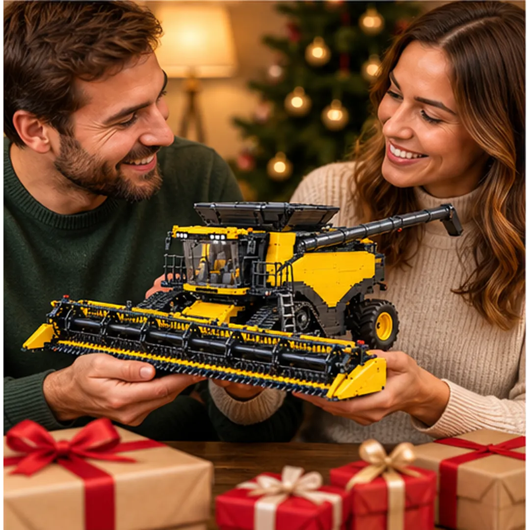 Couple smiling while admiring a completed yellow tracked grain combine collector building model beside wrapped holiday gifts