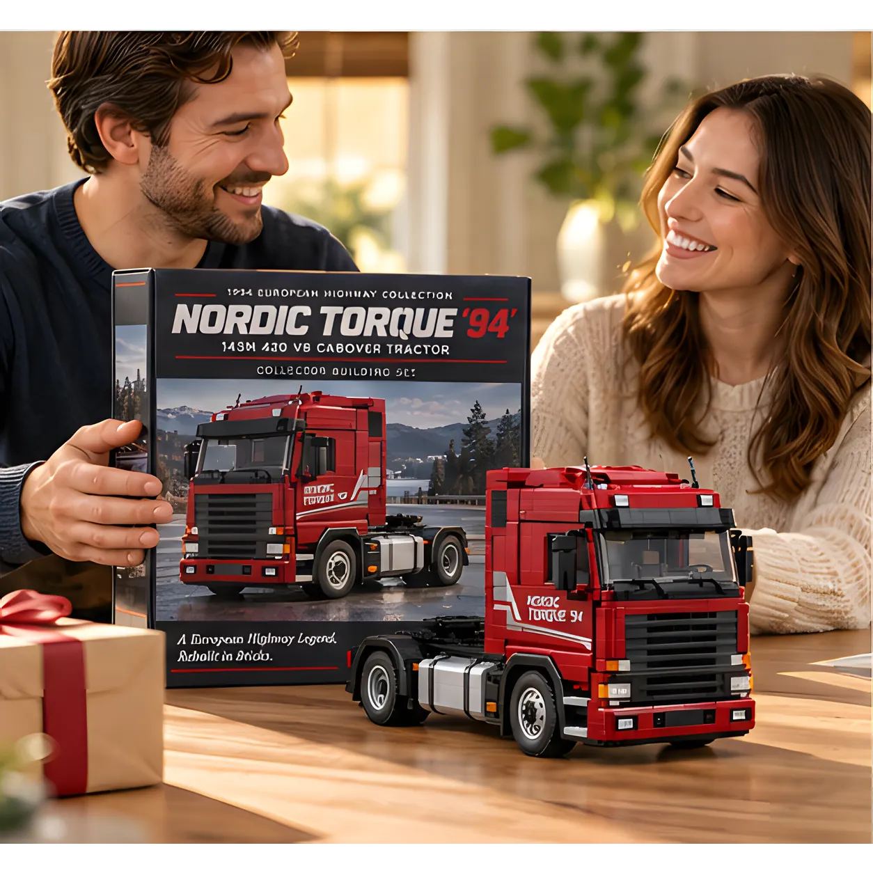 Two smiling adults with a boxed Nordic Torque '94 brick building set and the completed red cabover truck on a wooden table.