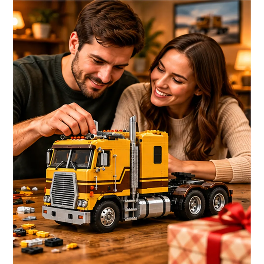 Two adults smiling while adding pieces to a yellow cabover truck building model, with a wrapped gift in the foreground