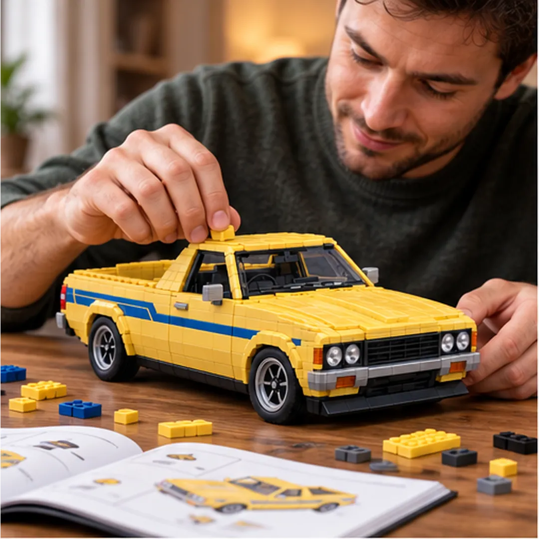 Adult builder fitting a yellow brick to the ute roof with spare pieces and illustrated assembly pages on the table