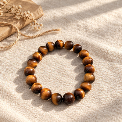 Yellow tiger eye bracelet on linen beside dried flowers