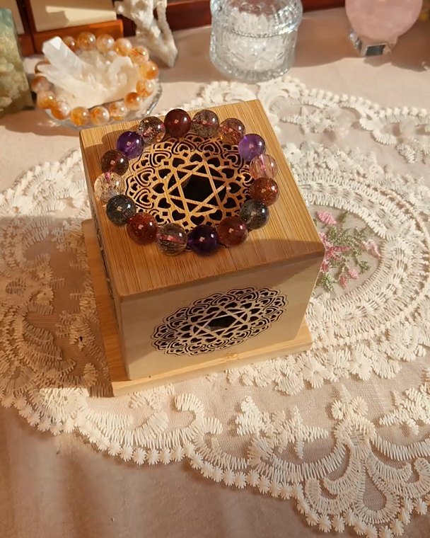 A bracelet resting on a carved wooden box in warm light