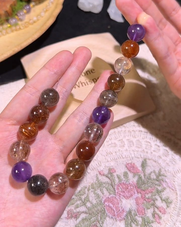 A finished strand of mixed quartz and amethyst beads on an open palm