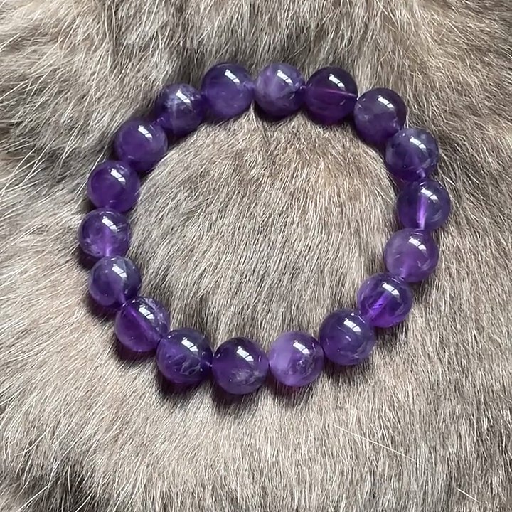 A deep purple amethyst bracelet on soft grey fur