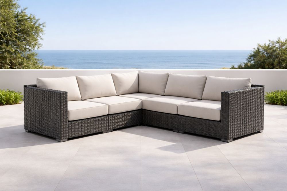 Divano angolare da esterno in rattan grigio con cuscini beige