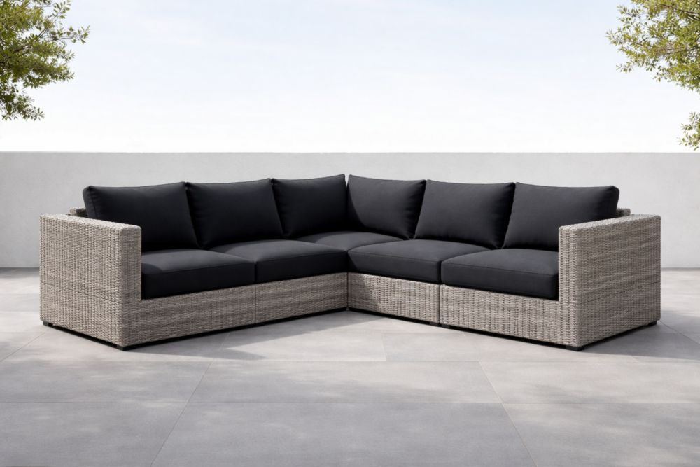 Divano angolare da esterno in rattan con cuscini neri